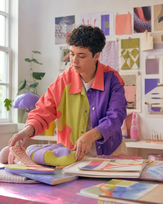 Fiktive Design-Creatorin Ivy in ihrem farbigen Atelier